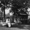 Hinsdale Sanitarium and Hospital patient and her nurse enjoying the Sanitarium grounds while more nurses enjoy time outdoors