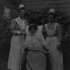 Unknown Battle Creek Sanitarium patient outdoors with two nurses, 1912