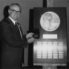 Clinton Emmerson is posing by Charles Elliot Weniger Award for Excellence plaque