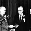 Owen A. Blake receives a desk pen holder from F. E. J. Harder