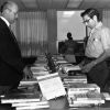 [Richard Powell assisting someone at the book exhibit in the James White Library]