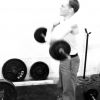 [Member of the Andrews University Barbell Club lifting weights]