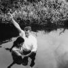 Andrews University Theological Seminary 1955 graduate, Clinton Shankel, baptizes the first young lady convert in Palau, East Caroline Island.