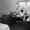 A student reading a book in a bedroom-study area of Andrews University Garland Apartments