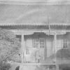 Chinese house with a man and women standing on the front porch