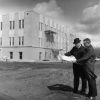 V. E. Garber and Andrews University construction manager, John Kriley, looking at blueprints for the Administration Building under construction in the background