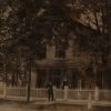 [Flavius J. and Harriet B. Littlejohn standing in front of their home in Allegan, Michigan with an unknown girl]