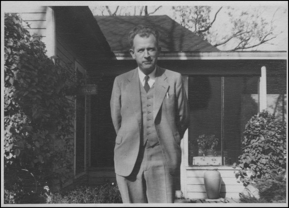 Joseph E. Sutherland standing in front of a house