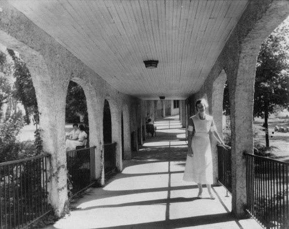 [Ellen Low standing in one of Madison Sanitarium's covered corridors]