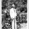 Edward Gates posing in front of tropical foliage