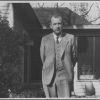 Joseph E. Sutherland standing in front of a house