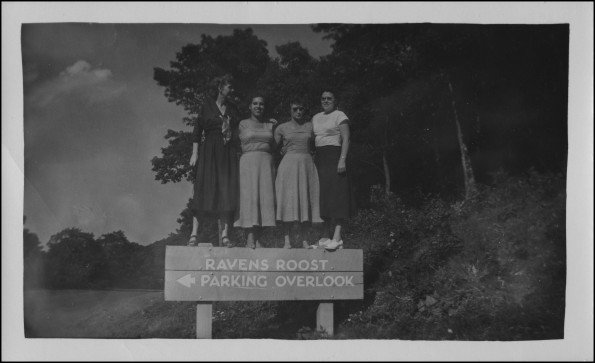 Four Madison ladies standing on the sign for Ravens Roost parking overlook