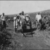 Myrna Beavon with her two sons Fred and Harold riding in a cart surrounded by natives