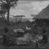 Kisii women thrashing corn with children surrounding