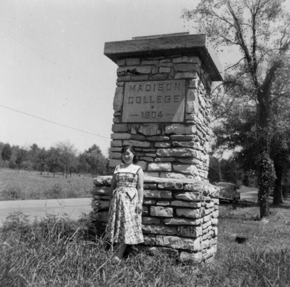 [Unknown girl standing by a sign for Madison College]