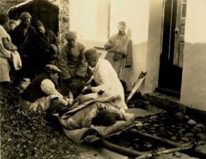 operation oudoors, on the ground. in the background a saw is leaning in the doorway.
