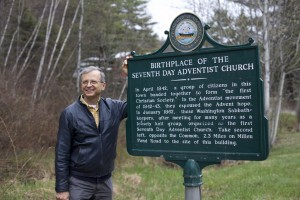 Jiří Moskala stands next to the historical marker indicating Washington, New Hampshire as the birthplace of the Seventh-day Adventsist Church.