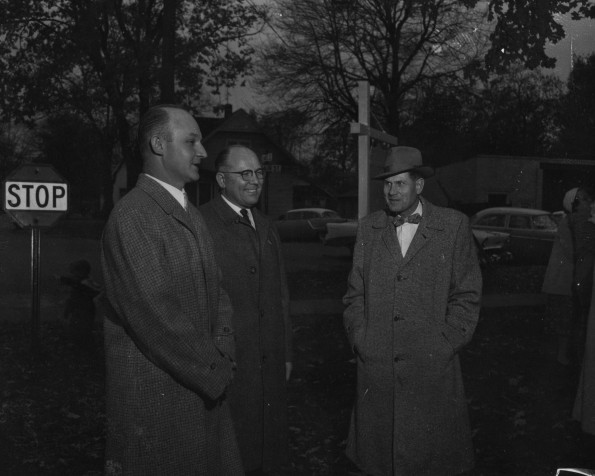 A. W. Bauer speaks with 2 men about Adventist welfare work
