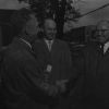 A. W. Bauer speaks with 2 men about Adventist welfare work