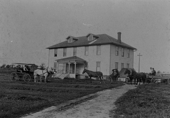 Cedar Lake Academy' dormitory building with Professor and Mrs. Lamson in the carriage with Nell. Adolf Evers and two of the boys driving the   greys   hitched to the Spring wagon. Irving Hall (now Dr. Hall) and Vinton Coskbam with the   Colts   attached to the wagon.