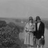 Two unknown women pose on a bluff overlooking a river or small lake
