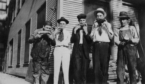 Unknown men eating watermelon