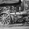 Unknown man and a very large tractor from the 1920's era or earlier
