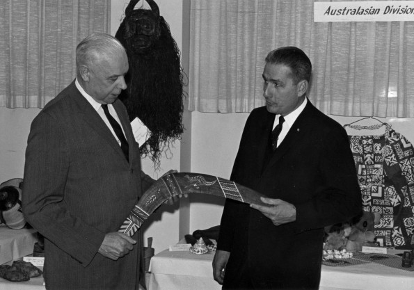William G. C. Murdoch looks at a boomerang from Australia at a missions display