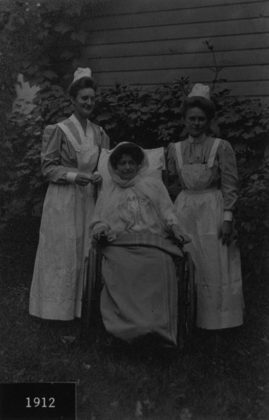 Unknown Battle Creek Sanitarium patient outdoors with two nurses, 1912