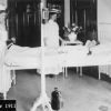 Battle Creek Sanitarium patient room with a patient and two attendants, 1912