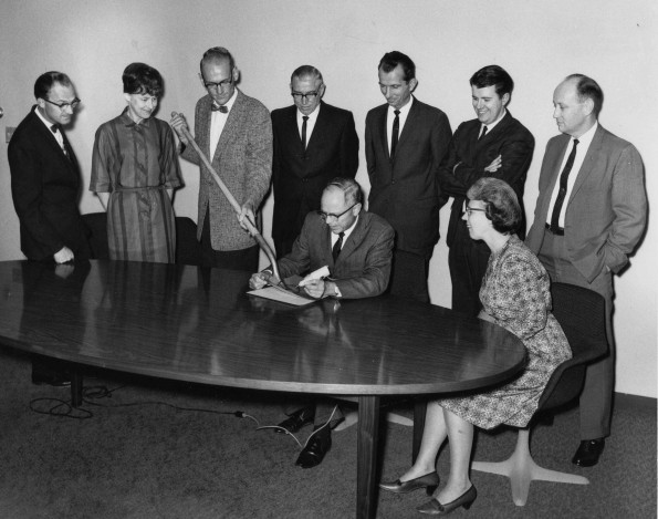 Andrews University president Richard L Hammill engraving the ground breaking shovel while unknown others look on