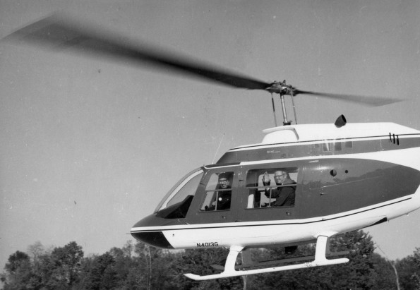 Andrews University Advisory Council Fly-in on a Bell Jet Ranger helicopter with President Richard Hammill waving from the helicopter
