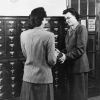 [Library staff at Emmanuel Missionary College library assisting student with looking up a book]