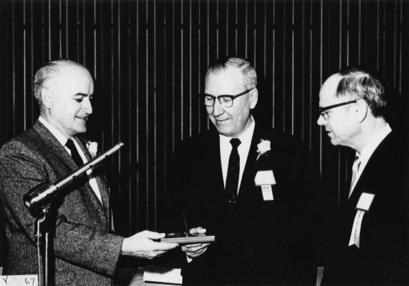 Andrews University alumnus of the year, Owen A. Blake, recieves a desk pen holder from alumni president, F. E. J. Harder, and Andrews University president, Richard L. Hammill