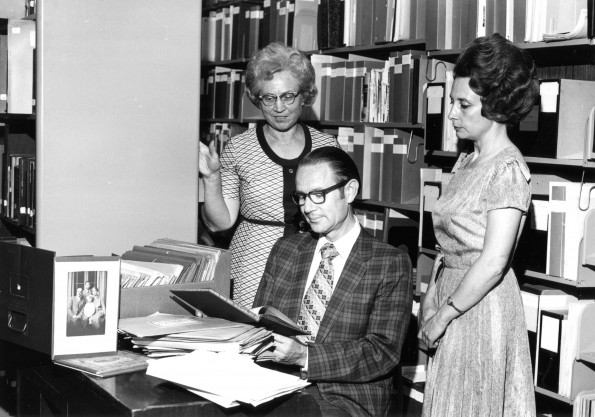 [Mary Jane Mitchell, C. Mervyn Maxwell, and Louise Dederen looking at documents in the Andrews University Heritage Room]