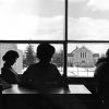 Andrews University students studying at the James White Library with Pioneer Memorial Church visible out of the window behind them