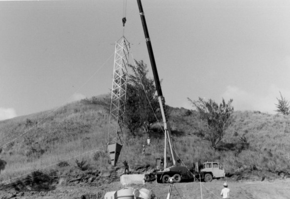 [Adventist World Radio-ASIA construction site, connected first two tower sections and base being hoisted into place by the crane]