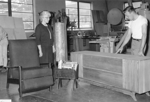 A student worker at Campus Wood Products shows an Andrews University Alumni Homecoming visit a piece of furniture