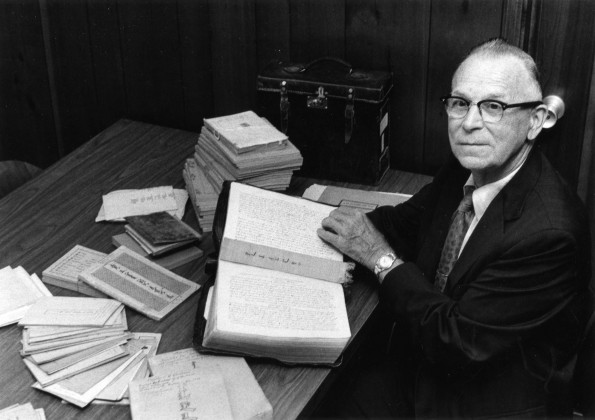 [Otto Christensen with a handwritten Old Testament in the Mongolian language displayed in the Andrews University Heritage Room]