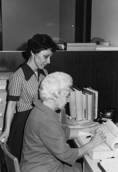 Two Andrews University staff members consult a list