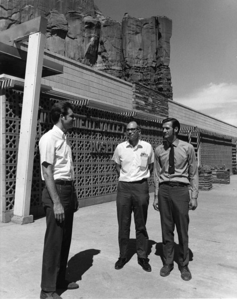 [Men standing in front of Monument Valley Hospital]