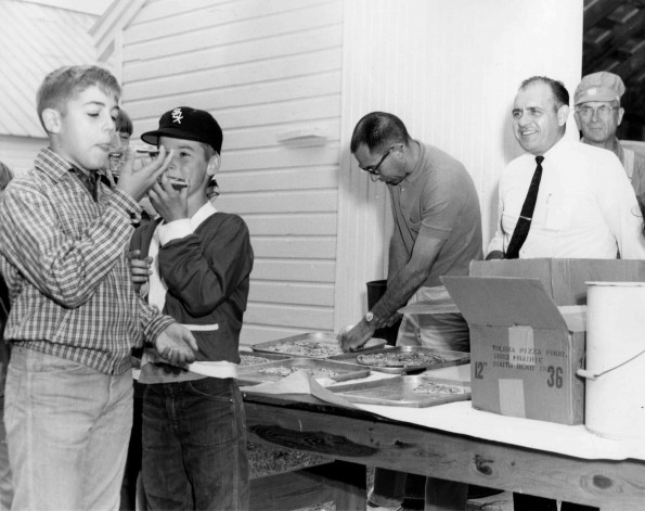 [Children eating pizza after community service work]