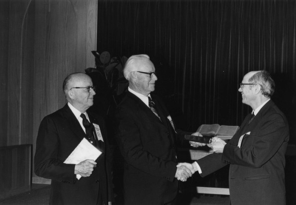 Andrews University alumna recieves a gift from Andrews University president, Richard L. Hammill as V. E. Garber looks on