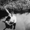 Andrews University Theological Seminary 1955 graduate, Clinton Shankel, baptizes the first young lady convert in Palau, East Caroline Island.