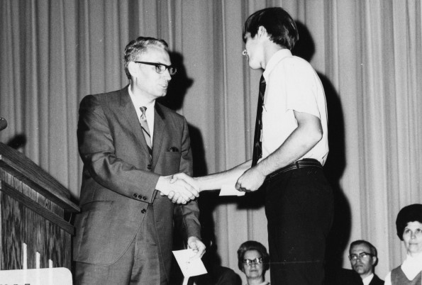 [Robert E. Firth, professor of business administration at Andrews University, presents the $150 Wilson & Verda Trickett schoalrship to junior business major Dick Hamstra.]