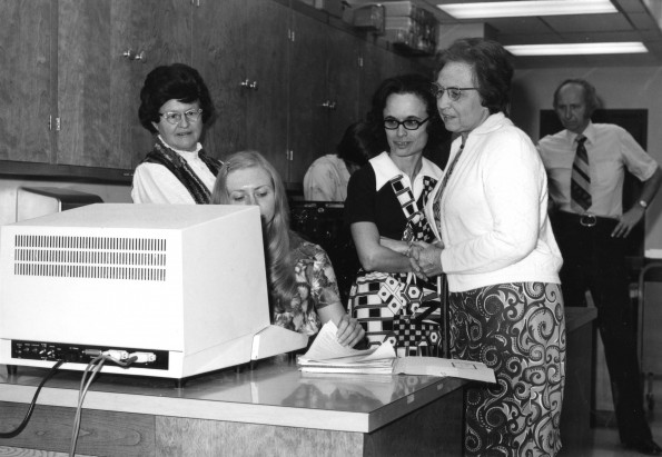 [Library staff using the new computer for cataloguing in the James White Library]