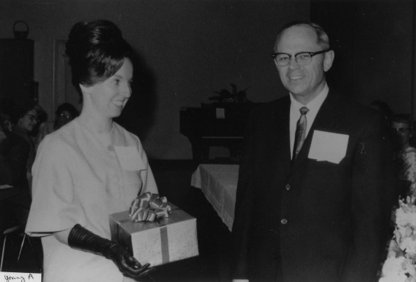 Andrews University young alumna of the year, Jaime Trefz, receives a gift from Andrews University president, Richard Hammill