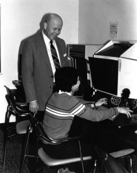 [Richard K. Powell assisting someone in the James White Library]
