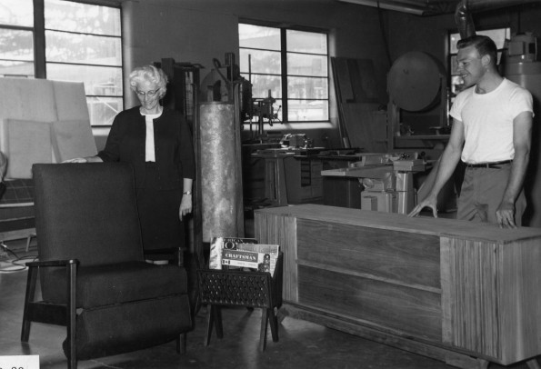A student worker at Campus Wood Products shows an Andrews University Alumni Homecoming visit a piece of furniture