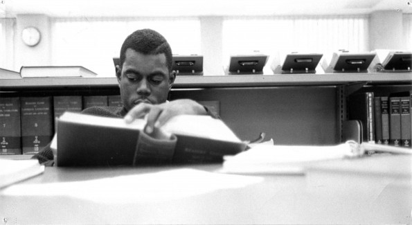 [A student reading in the Periodical Room of the James White Library]